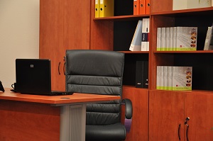 brązowe meble biurowe i czarny fotel